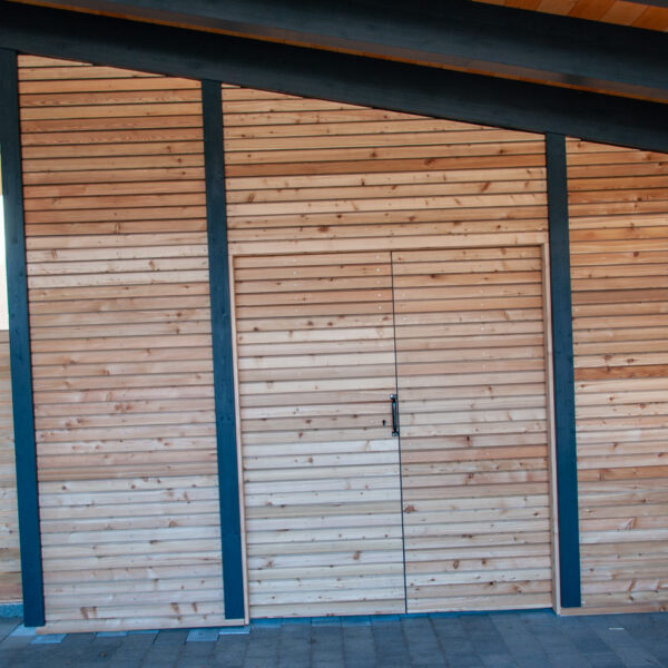 Doppelflügeltüre aus Holz in Seitenwand des Carports eingebaut