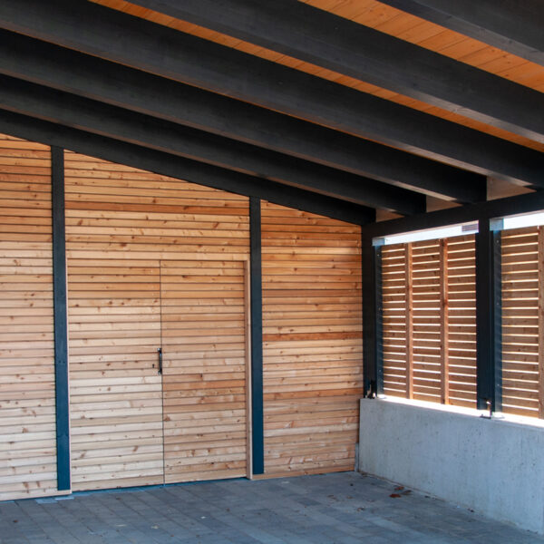 Innenansicht des Carports mit sichtbarer Holzdecke und offener Lamellenverkleidung