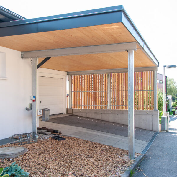 Komplettansicht eines Carports mit Holzverkleidung, Stahlstützen und Betonfundament.